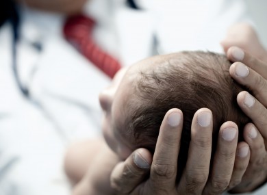 File image of a baby in a doctor's arms.