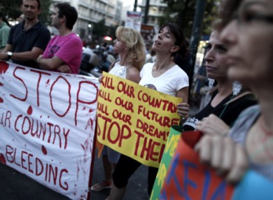 Protesting civil servants hold banners during a rally in central Syntagma Square outside the Greek Parliament yesterday.