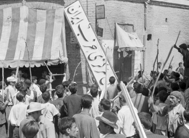 Demonstrators tear down the Iran Party's sign in Tehren on 19 August 1953
