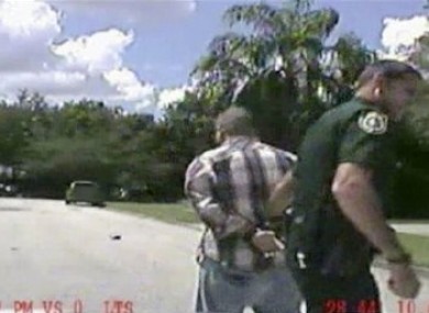 In this image made from dash-cam video and released by the Lake Mary (Florida) Police, George Zimmerman is detained by officers on Monday, 9 September, 2013 after Police in central Florida were called via 911 by Shellie Zimmerman saying her estranged husband was in his truck and threatening her and her father with a gun.