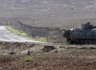A Turkish tank stands near a fence of the Turkish-Syrian border.