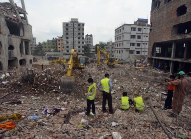 Workers examine the site of the collapsed garment factory in Savar near Dhaka.