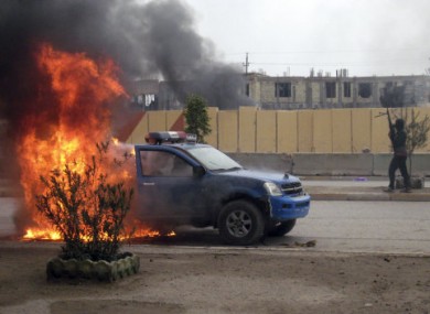 An al-Qaeda fighter stands guard after setting fire to an Iraqi police truck in Fallujah.