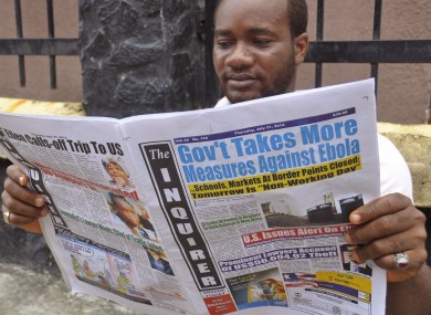 In Liberia, a man reads a newspaper with headlines reading 'Gov't Takes More Measures Against Ebola, as fear about the virus spread in the city of Monrovia.