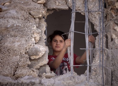 Child looks out from the damaged family home of Palestinian Ziad Awad in the town of Idna,13 kilometers west of the West Bank city of Hebron.