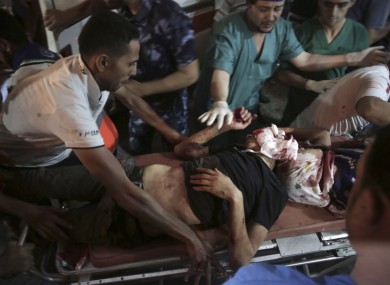 Medics wheel two wounded Palestinians into the emergency room of Shifa hospital in Gaza City.