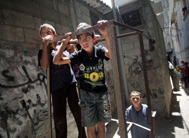 Palestinian children look at mourners carrying the bodies of Roshdi, Mohammed and Reyad Naser during their funeral in the southern Gaza Strip on Saturday.