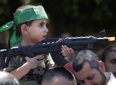 A Palestinian boy holds a toy gun at a Hamas rally in Gaza City today
