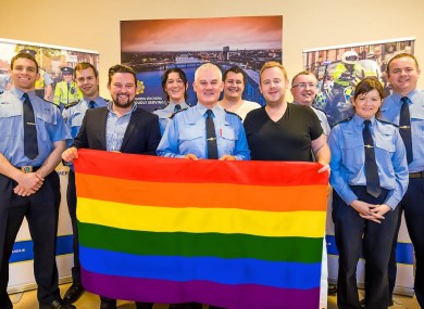 Gardaí at Henry Street station in Limerick smile while they stand behind a rainbow flag with Gay Pride organisers.