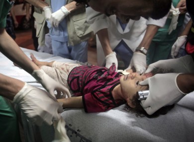 Palestinian medics treat a two-yea-old child injured in an Israeli strike.