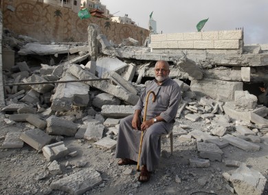 A Palestinian sits in the rubble of the house of Hussam Kawasma, one of three Palestinians identified by Israel as suspects in the killing of three Israeli teenagers, after it was demolished by the Israeli army in the West Bank city of Hebron yesterday.