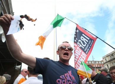 A protester burns a water bill on O'Connell Street during a demonstration against water charges in June.