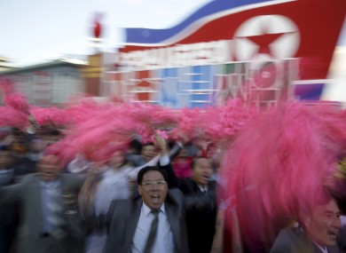 North Koreans wave decorative flowers as they parade in Pyongyang, North Korea.