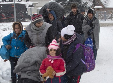 A group of migrants move through snow towards a train station to be transferred to Austria, near the border with Croatia, in Dobova, Slovenia,
