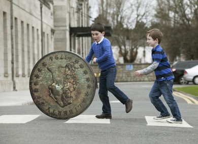 Six year olds Paddy Dwyer and William Hegarty from Foxrock and a replica of the coin. The real coin is much smaller.
