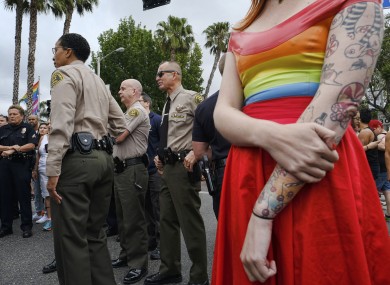 A woman stands next to Los Angeles County Sheriff's deputies and police as they gather prior to the Gay Pride parade in West Hollywood, California yesterday.