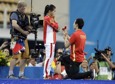 China's silver medalist He Zi, left, receivers a marriage proposal by China's diver Qin Ki, right, during the medal ceremony for the the women's 3-meter springboard diving final.