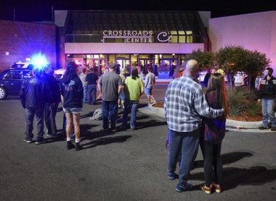 People stand near the entrance on the north side of Crossroads Center mall during the incident last night.