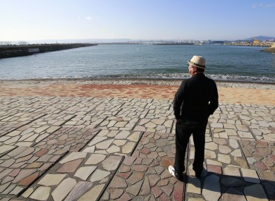 A man looks to sea after the tsunami warning was lifted at Onahama coastal region in Iwaki, in the Fukushima prefecture of northeastern Japan today.
