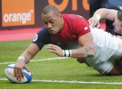 Gael Fickou of France scores a try while being tackled by Scotland's Stuart Hogg.