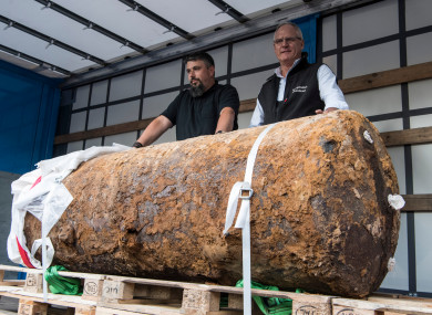 Bomb disposal experts showcasing the hefty British bomb afterwards