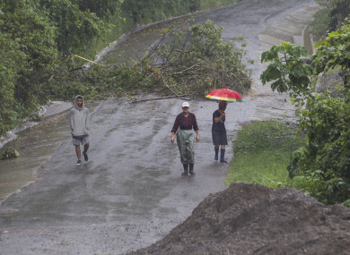 People walk along a washed out road on the outskirts of San Jose, Costa Rica