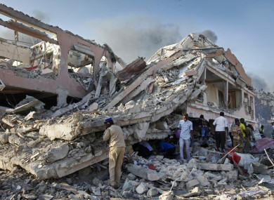 Somalis gather and search for survivors by destroyed buildings at the scene of a blast in the capital Mogadishu, Somalia.