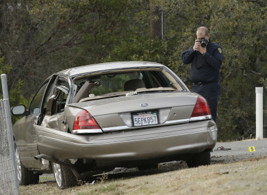 A California Highway patrol officer photographs a vehicle involved in a deadly shooting rampage at the Rancho Tehama Reserve