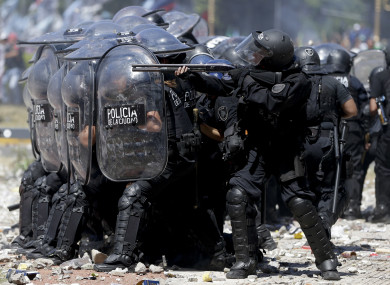 A police officer fires rubber bullets at demonstrators during a general strike against a pension reform measure in Buenos Aires, Argentina, earlier this month.