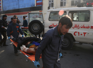 People carry an injured man from the blast site near Sidarat Square in Kabul, Afghanistan.