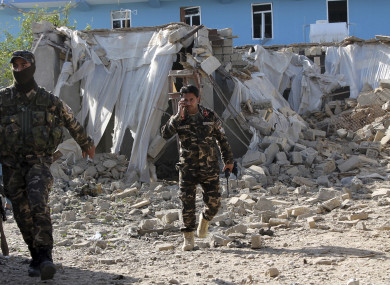Security forces inspect in an explosion site in Lashkar Gah