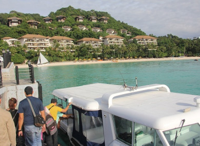 Tourists board a speedboat near a forestland area on Boracay island in Malay town, Aklan province, central Philippines