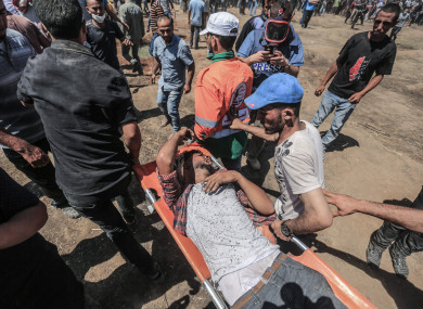 Palestinians evacuate an injured man during clashes with Israeli Security Forces along the Israel-Gaza border