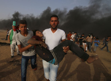 Palestinian protesters carry a wounded person during clashes with Israeli troops near the Gaza-Israel border on Friday.