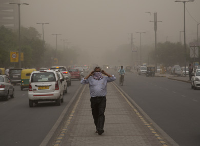 A man wraps a scarf around his nose as a dust storm envelops the city in New Delhi, India.