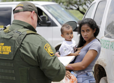 A woman from Honduras with her child surrendering to US border patrol agents.