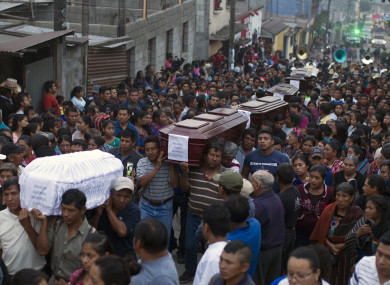 People carry to the cemetery the coffins of seven people who died during the eruption of the Volcan de Fuego on Monday in Guatemala.