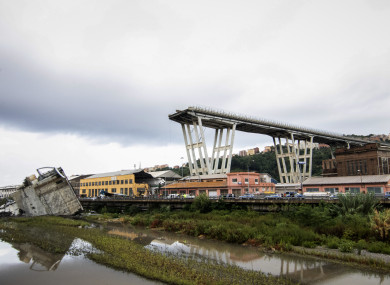 A picture taken on Tuesday shows vehicles standing on a part of a Morandi motorway bridge after a section collapsed earlier in Genoa