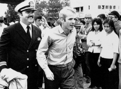In this 14 March 1973 photo US Navy Lt Cmdr John McCain (centre) is escorted by Lt Cmdr Jay Coupe Jr to Hanoi's Gia Lam Airport after McCain was released from captivity in Vietnam.