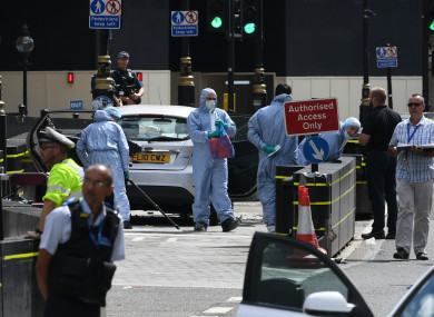 Forensic officers by the car that crashed into security barriers outside the Houses of Parliament.