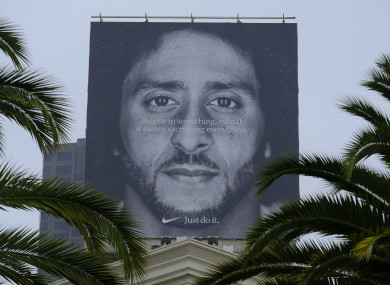 Palm trees frame a large billboard on top of a Nike store that shows former San Francisco 49ers quarterback Colin Kaepernick.