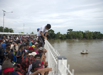 Migrants climbing a border bridge in Guatemala