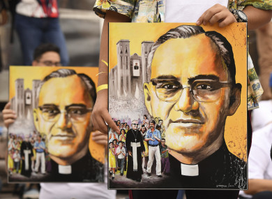 People hold pictures of Archbishop Oscar Romero in San Salvador.