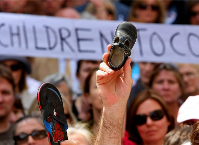 A child's shoe is held up as thousands of victims of institutional abuse survivors during the silent demonstrations in memory of the victims in Dublin city centre to the Dail in 2009.