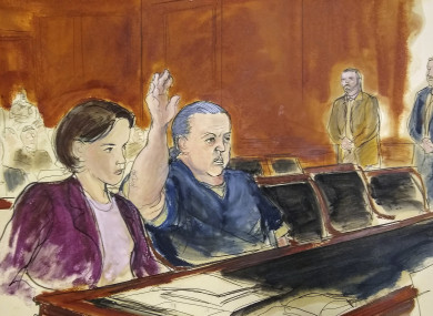 In this courtroom sketch, pipe bombs suspect Cesar Sayoc seated in court, raises his arm to swear to the truth of his statement of need for assigned counsel.