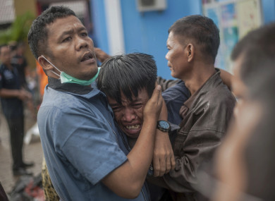 A man reacts are identifying the body of a family member in Carita, Indonesia.