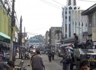 Soldiers and police cordon off the area after two bombs exploded outside a Roman Catholic cathedral in the Philippines.