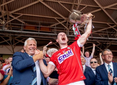 Jerry O'Sullivan presents the Munster senior hurling trophy last year to Cork captain Seamus Harnedy.