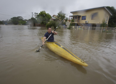 A man kayaking in flood waters in Hermit Park Townsville, Australia.