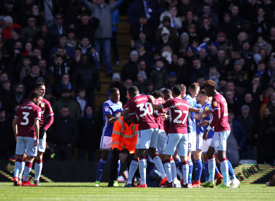 Aston Villa players swarm around Jack Grealish after he is punched by a fan.